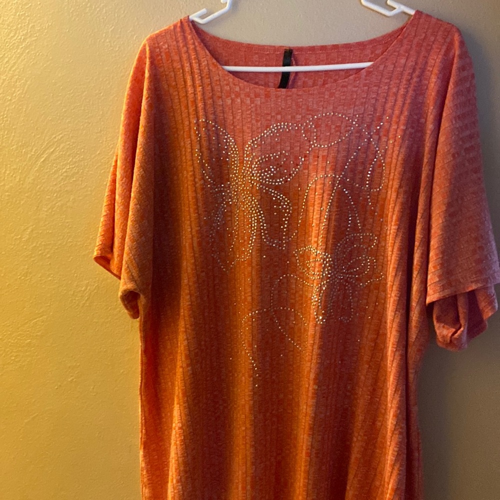 Woman’s orange top with studs some studs are missing